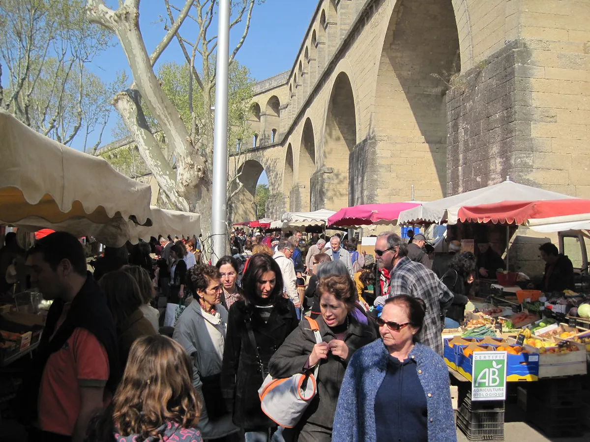 Marché des Arceaux in Montpellier showing market stalls beneath historic stone aqueduct arches