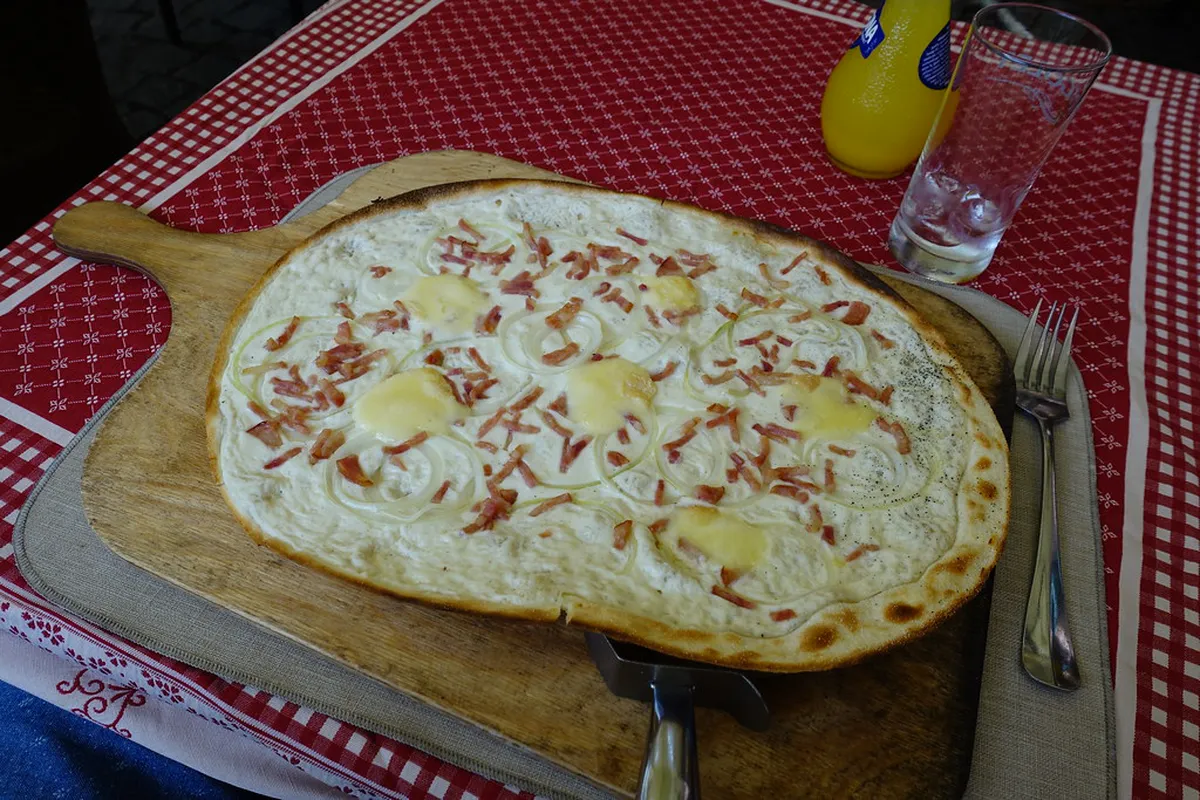 Alsatian Flammekueche tarte flambee with crispy flatbread and traditional toppings