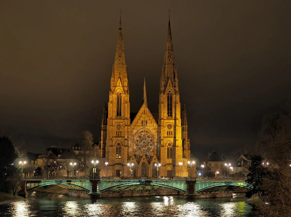 Strasbourg Cathedral illuminated at night with glowing light projections on the façade